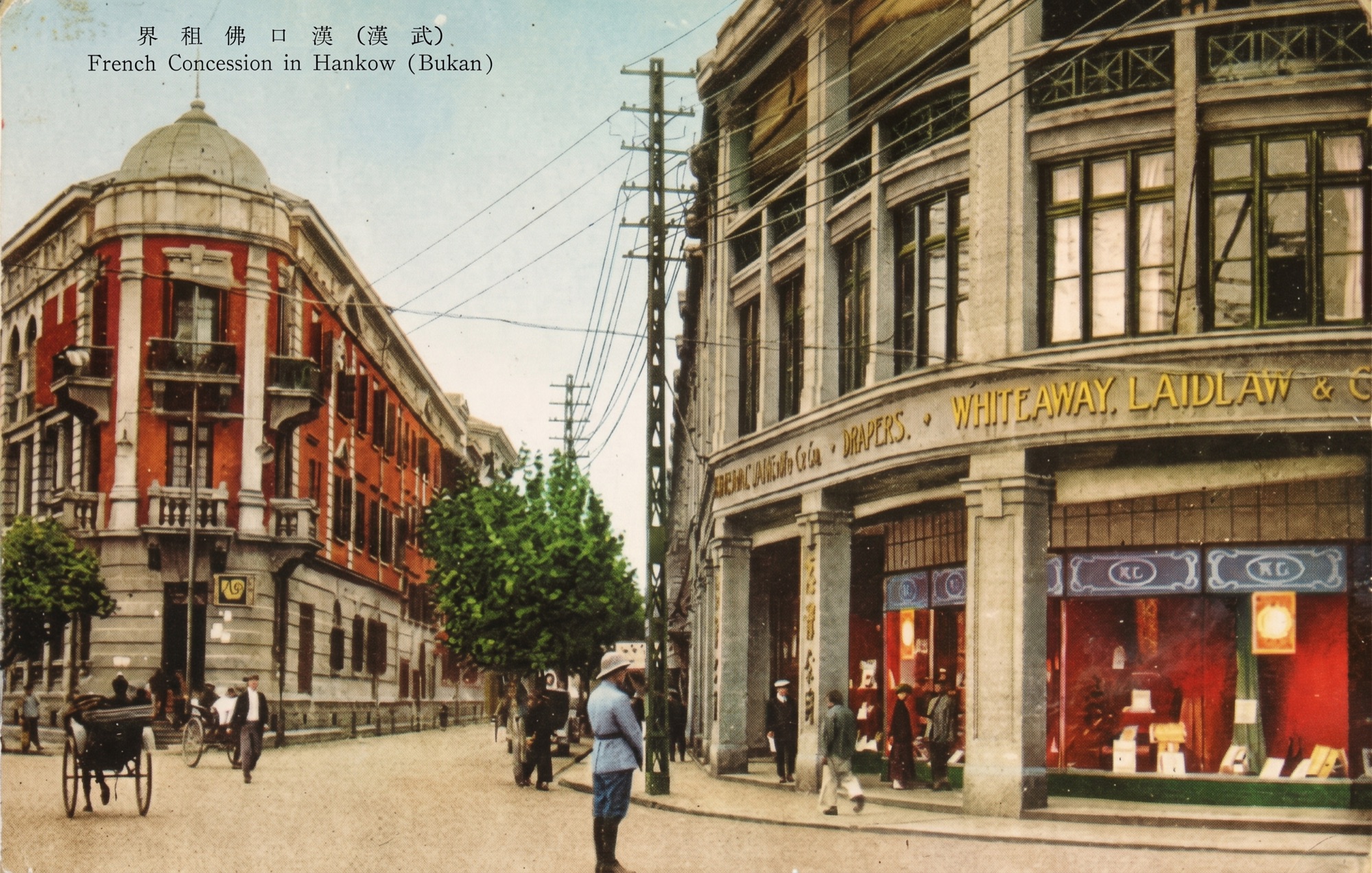 A colorized vintage postcard of the French Concession in Hankow: a red-brick corner building with a dome, the Whiteaway Laidlaw drapers on the right, and a policeman in a pith helmet in the street